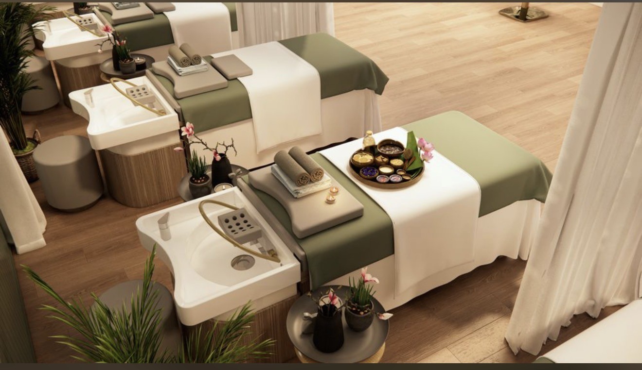 Head spa treatment beds with sage linens, white drapery and warm wood finishes